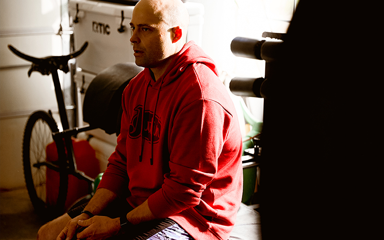 Dusty sitting in gym wearing Justin sweatshirt 